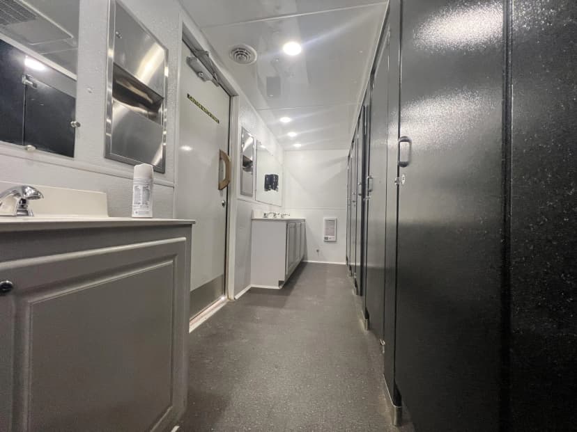 VIP restroom trailer interior with vanity and private stalls